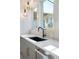 Modern kitchen with black sink, matte black faucet, and geometric lighting at 160 Cedarwood Ln, Roswell, GA 30075