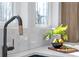Close-up of a modern kitchen with a black sink, white backsplash, quartz countertops, and black faucet at 160 Cedarwood Ln, Roswell, GA 30075
