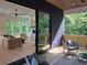 Modern living room open to a covered outdoor patio with sliding glass doors and wooded views at 160 Cedarwood Ln, Roswell, GA 30075