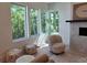 Cozy living space with a fireplace, stylish seating, and natural light streaming through large windows at 160 Cedarwood Ln, Roswell, GA 30075