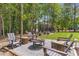 Inviting outdoor space with seating, a fire pit, and views of the surrounding lush greenery at 160 Cedarwood Ln, Roswell, GA 30075