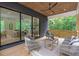 Stylish covered patio with wood ceiling, comfortable seating, and sliding glass doors to the living room at 160 Cedarwood Ln, Roswell, GA 30075