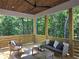 Relaxing outdoor patio with wood ceiling, comfortable seating, and view of lush greenery at 160 Cedarwood Ln, Roswell, GA 30075