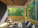 Beautiful covered outdoor patio with stylish seating, wood ceiling, and peaceful wooded views at 160 Cedarwood Ln, Roswell, GA 30075
