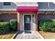 Front entrance with red awning, brick accents, and lush landscaping at 3301 Henderson Mill Rd, Atlanta, GA 30341