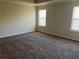 Spacious carpeted bedroom with two large windows and neutral walls at 606 Grenier Ter, Lawrenceville, GA 30045