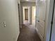 Hallway with doors to bedrooms and carpet flooring at 606 Grenier Ter, Lawrenceville, GA 30045