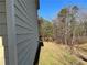 Exterior view showcasing light beige siding and wooded area at 606 Grenier Ter, Lawrenceville, GA 30045