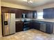 Kitchen with dark wood cabinets, stainless steel appliances, and tile floor at 606 Grenier Ter, Lawrenceville, GA 30045