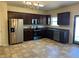 Eat-in kitchen with dark wood cabinets, stainless steel appliances, and tile floor at 606 Grenier Ter, Lawrenceville, GA 30045