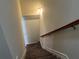 Carpeted staircase with wooden handrail leading downstairs at 606 Grenier Ter, Lawrenceville, GA 30045