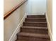 Carpeted staircase with wooden handrail, leading to the upper level at 606 Grenier Ter, Lawrenceville, GA 30045