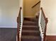 Carpeted staircase with dark wood railings, connecting floors of the home at 606 Grenier Ter, Lawrenceville, GA 30045