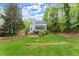 Spacious backyard featuring well-maintained lawn, mature trees, a wooden fence, and a deck off the back of the home at 3616 Longfellow Trl, Marietta, GA 30062