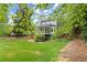 Large backyard featuring green lawn, mature trees, wooden fence, and a deck off the back of the house at 3616 Longfellow Trl, Marietta, GA 30062