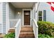 Close-up of a charming front entrance with a wooden door, brick steps, and white railing at 3616 Longfellow Trl, Marietta, GA 30062