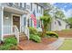 Inviting brick front porch with decorative shrubs and a wooden front door, featuring an American flag at 3616 Longfellow Trl, Marietta, GA 30062