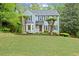 Traditional home featuring a large front yard, mature trees, and blue shutters on a sunny day at 3616 Longfellow Trl, Marietta, GA 30062