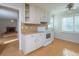 Cozy kitchen with white cabinets, laminate countertops, wood floors and a view into the living room at 3640 Longfellow Trl, Marietta, GA 30062