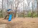 Playground with slide and swings surrounded by tall trees and woodchips, providing a fun and safe play area at 3640 Longfellow Trl, Marietta, GA 30062