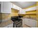 Galley kitchen with granite countertops and white cabinets at 3599 Woodbriar Cir # G, Tucker, GA 30084