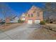 Traditional brick home featuring a two-car garage, manicured landscaping and a long driveway on a sunny day at 3643 Southland Ne Dr, Buford, GA 30519