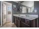 Gray bathroom featuring dual sinks, dark cabinets, and a view of the outdoors at 529 Dasheill Ln, Atlanta, GA 30349