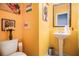 Bright yellow powder room with modern fixtures and unique artwork at 529 Dasheill Ln, Atlanta, GA 30349