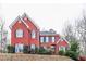 Two story red brick house with dark shutters at 7715 Bold Springs Xing, Cumming, GA 30041