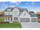 Two-story farmhouse with gray accents, three-car garage, and landscaped yard at 2799 Porches Ln, Dacula, GA 30019