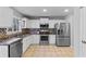 Modern kitchen features stainless steel appliances, white cabinets, tile flooring and countertops at 1878 Hamby Place Nw Dr, Acworth, GA 30102