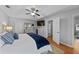 A main bedroom with hardwood floors, a ceiling fan, a TV, and two doors leading to other areas at 1878 Hamby Place Nw Dr, Acworth, GA 30102