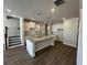 Open-concept kitchen featuring a granite island, stainless fixtures, white cabinets, and hardwood floors at 216 Depot Landing Rd # 61, Auburn, GA 30011