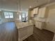 Open-concept kitchen featuring a granite island, stainless fixtures, white cabinets, and hardwood floors at 216 Depot Landing Rd # 61, Auburn, GA 30011