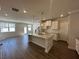 Open-concept kitchen featuring a granite island, stainless fixtures, white cabinets, and hardwood floors at 216 Depot Landing Rd # 61, Auburn, GA 30011