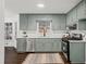 Renovated kitchen with light green cabinets, stainless steel appliances, and white countertops at 425 Shepard Sw Dr, Marietta, GA 30064