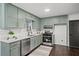 Renovated kitchen with light green cabinets, quartz countertops, and stainless steel appliances at 425 Shepard Sw Dr, Marietta, GA 30064