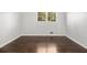Empty bedroom with hardwood flooring, white walls, and a window bringing in natural light at 2540 Thornton Dr, Atlanta, GA 30349