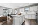 Open kitchen with white cabinets, center island, and hardwood floors at 630 Pineberry Ct, Grayson, GA 30017