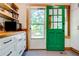 Kitchen with green door, white cabinets, and wood countertops at 1576 Temple Ave, Atlanta, GA 30337