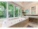 Luxurious bathroom with a soaking tub and large windows overlooking the garden at 1020 W Wesley Nw Rd, Atlanta, GA 30327