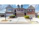 Three-unit townhome community with attached garages and manicured landscaping at 3457 Sardis Bend Dr, Buford, GA 30519