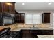 Kitchen features dark cabinets, granite countertops, and a gas range at 3457 Sardis Bend Dr, Buford, GA 30519