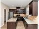 Modern kitchen with dark cabinets, granite countertops, and stainless steel appliances at 3457 Sardis Bend Dr, Buford, GA 30519