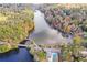 Scenic aerial view of community lake surrounded by colorful fall foliage and featuring a pool and bridge at 115 Russell Rd, Roswell, GA 30075
