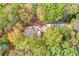 Bird's eye view of a distinguished home embraced by a canopy of trees in full autumnal splendor at 115 Russell Rd, Roswell, GA 30075