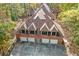 Aerial view showcasing a large brick home with a four-car garage nestled in a lush, wooded setting at 115 Russell Rd, Roswell, GA 30075