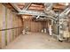 Unfinished basement with exposed utilities and framing, showcasing potential for customization at 115 Russell Rd, Roswell, GA 30075