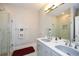 Bright bathroom features double vanity with granite counters and shower with glass door at 115 Russell Rd, Roswell, GA 30075