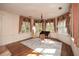 Bedroom featuring hardwood floors, large windows, and decorative window treatments at 115 Russell Rd, Roswell, GA 30075